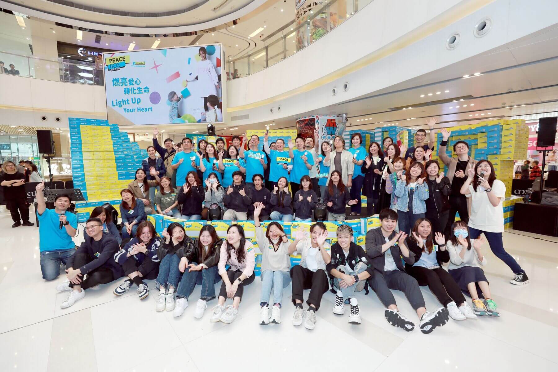 义工们将5,000多个PeaceBox 盒砌成「LIGHT」，展示在商场内，让市民拍照留念。启动礼后，随即将礼物盒送到有需要的人手上。